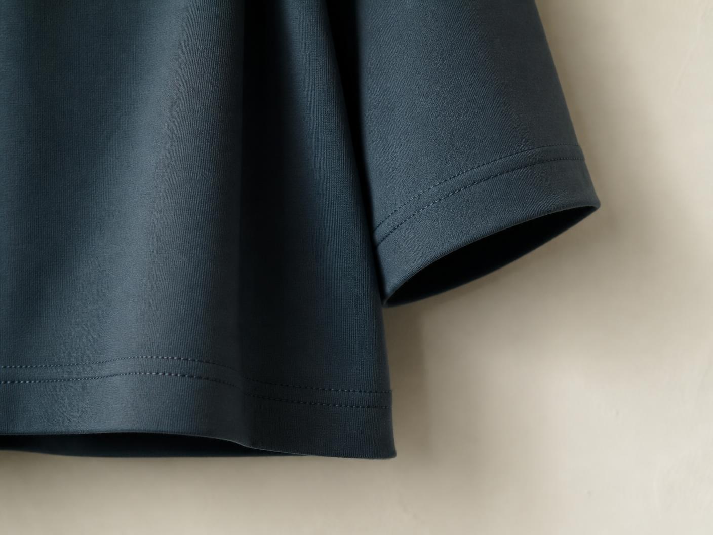 Macro de la bas de corps et du bord de manche du t-shirt, surpiqûre double aiguille